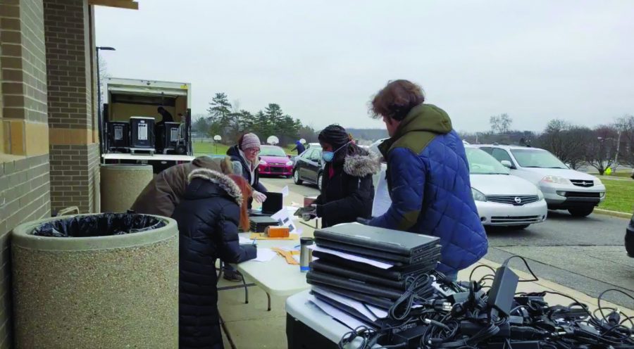 Volunteers sign out computers to families at Tappan Middle School on March 24. 