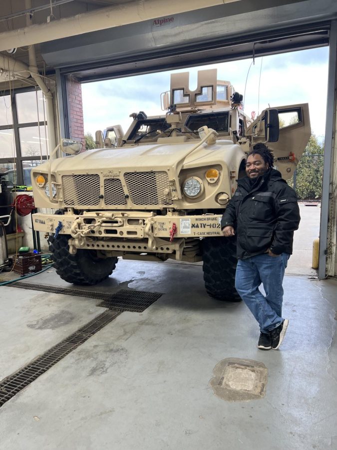 Kenneth Lewis II, lead CTE Automotive instructor at Pioneer, stands next to a military M-ATV, a mine-resistant ambush protected vehicle developed by the Oshkosh Corporation for the U.S. militarys All Terrain Vehicle program. The vehicle visited Lewiss classroom Thursday, Dec. 15, for the day so his automotive students could explore its features.